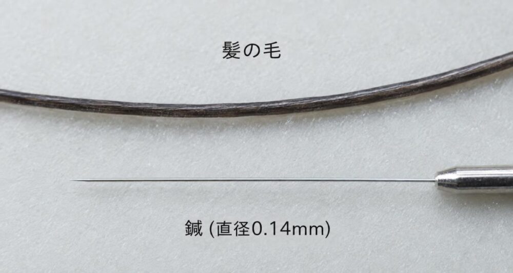 髪の毛と並べた直径0.14mmの極細鍼